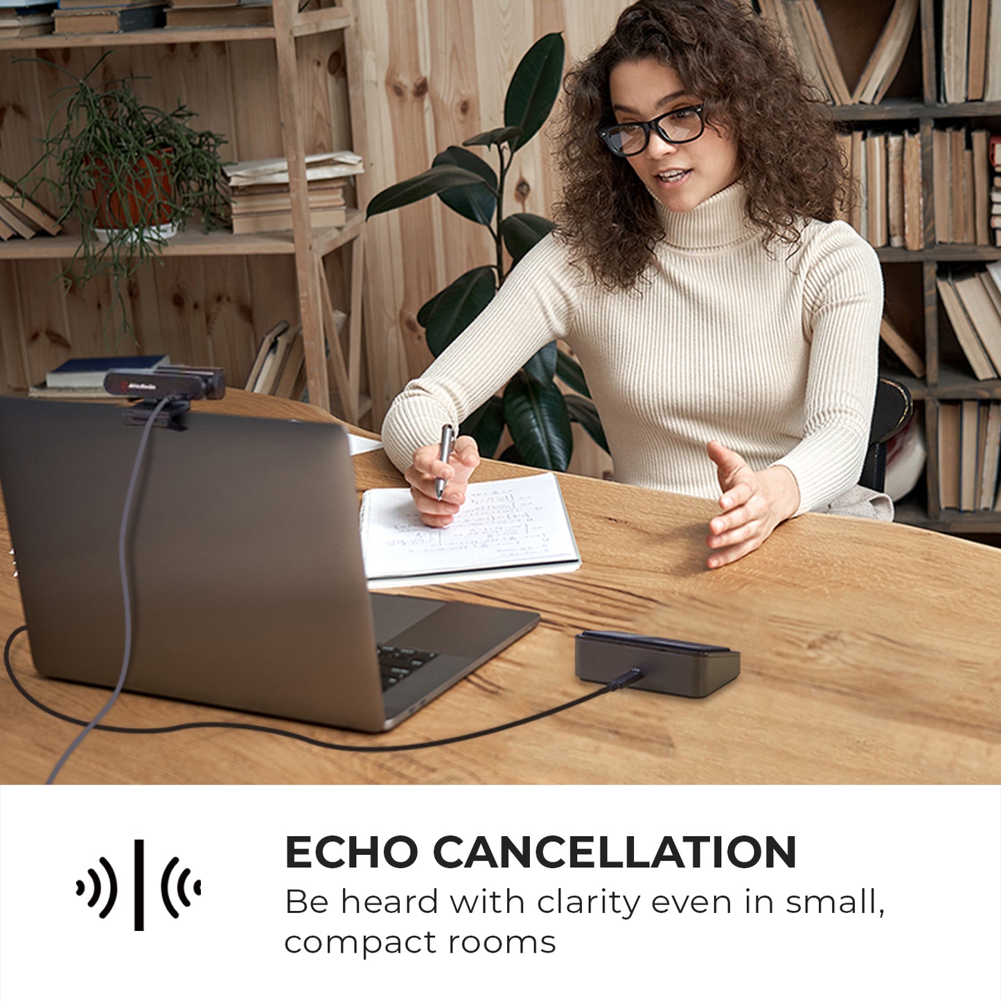 Woman having a meeting with conference speakerphone while taking notes